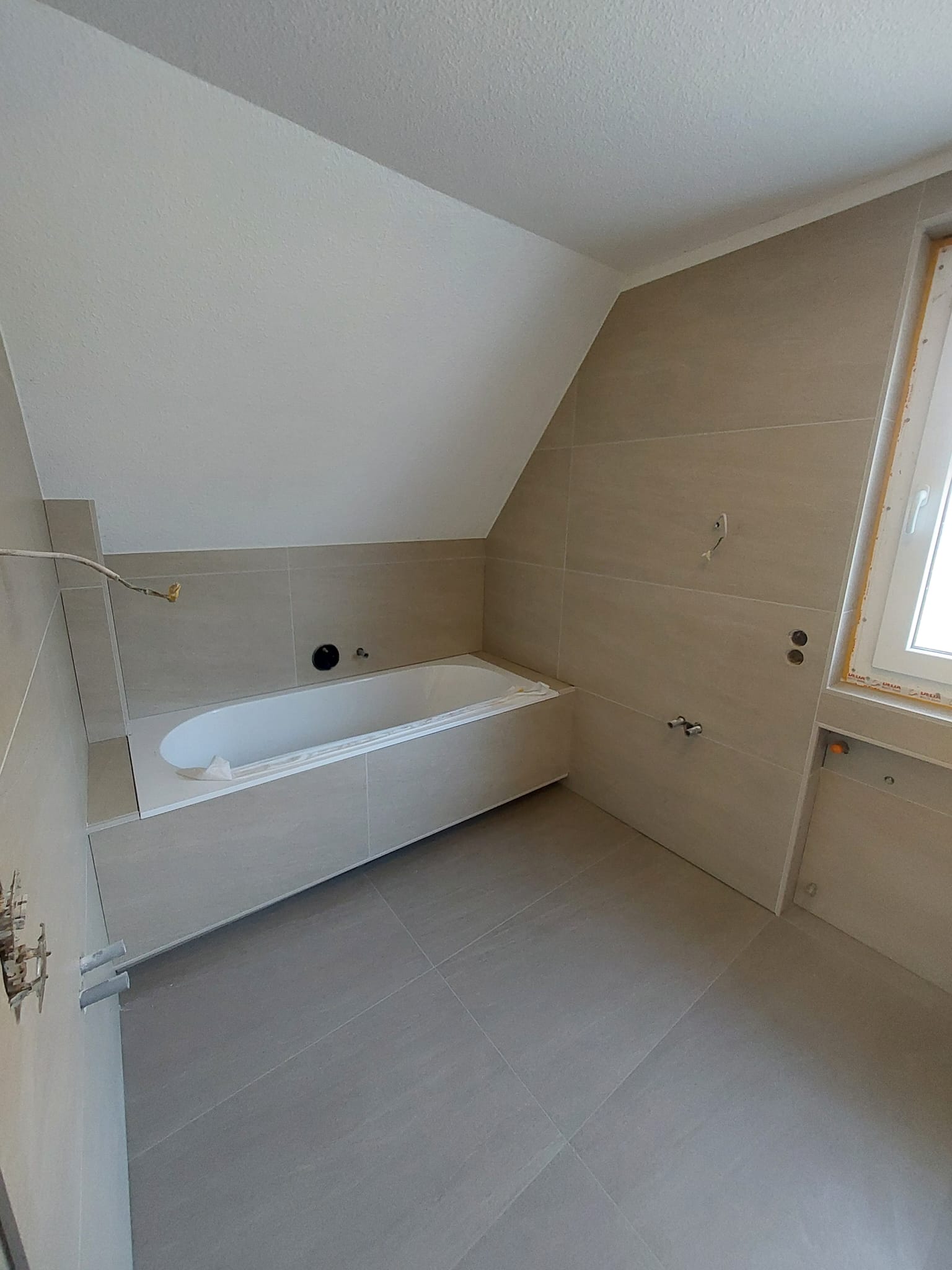 Fliesenarbeiten im Bad mit ruhiger Wannenlösung